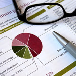 Financial concept - pie chart showing investment portfolio breakdown, glasses and pen support analysis,review theme