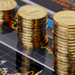 Downtrend stacks coins,on the financial stock charts as background. Selective focus