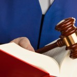 Ein Richter mit einem Gesetzbuch bei Gericht. Gavel in der Hand.